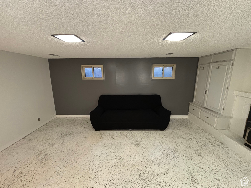 Living area with baseboards and a textured ceiling