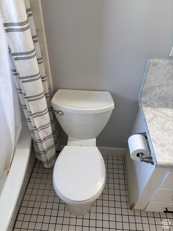 Bathroom with shower / bathtub combination with curtain, toilet, and tile patterned flooring