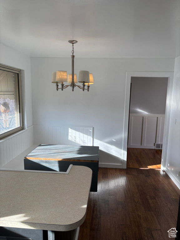 Dining space featuring a chandelier, visible vents, wainscoting, and dark wood-type flooring