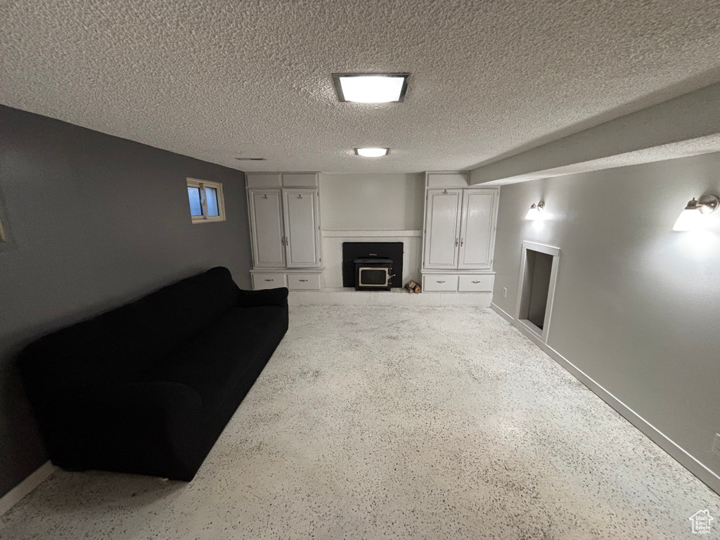 Unfurnished living room featuring a textured ceiling and a fireplace