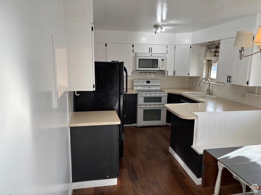 Kitchen featuring a sink, white appliances, tasteful backsplash, and light countertops