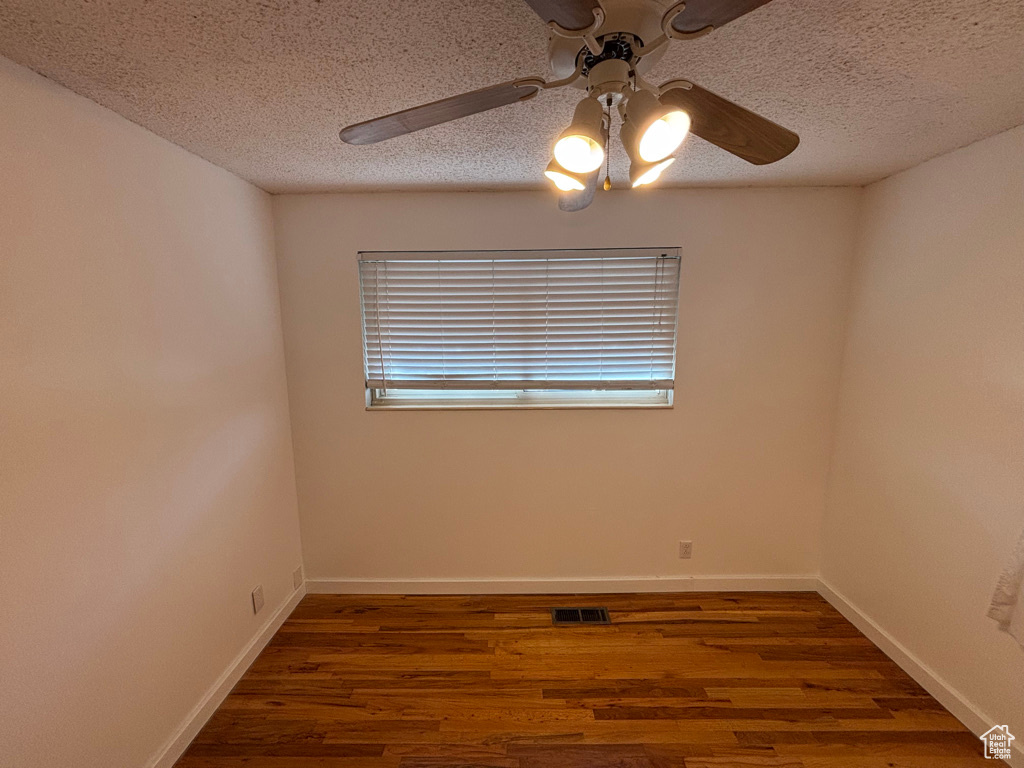 Spare room with visible vents, a textured ceiling, and wood finished floors