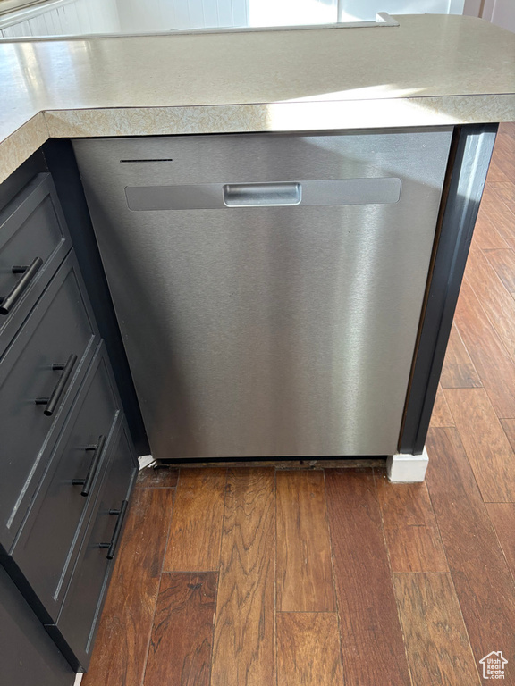 Interior details with gray cabinetry, light countertops, dark wood-type flooring, and stainless steel dishwasher