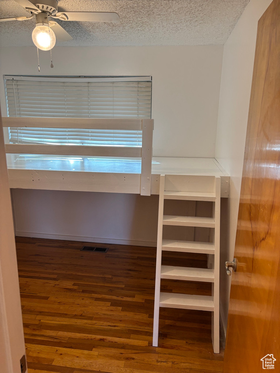 Interior space with visible vents, a textured ceiling, and wood finished floors