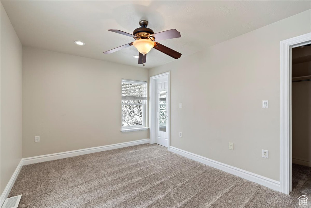 Carpeted spare room with recessed lighting, visible vents, baseboards, and ceiling fan