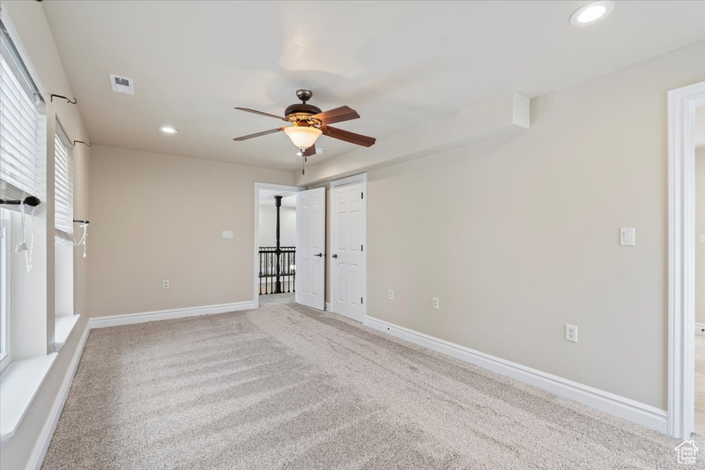 Empty room with visible vents, baseboards, ceiling fan, light colored carpet, and recessed lighting