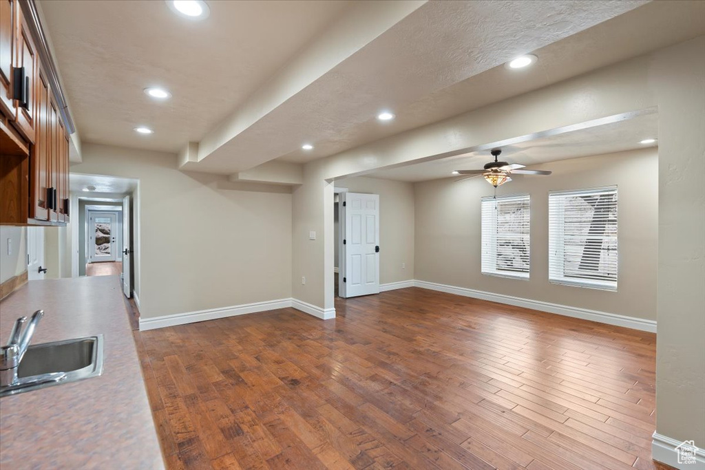 Kitchen with dark wood-type flooring, recessed lighting, baseboards, and a sink