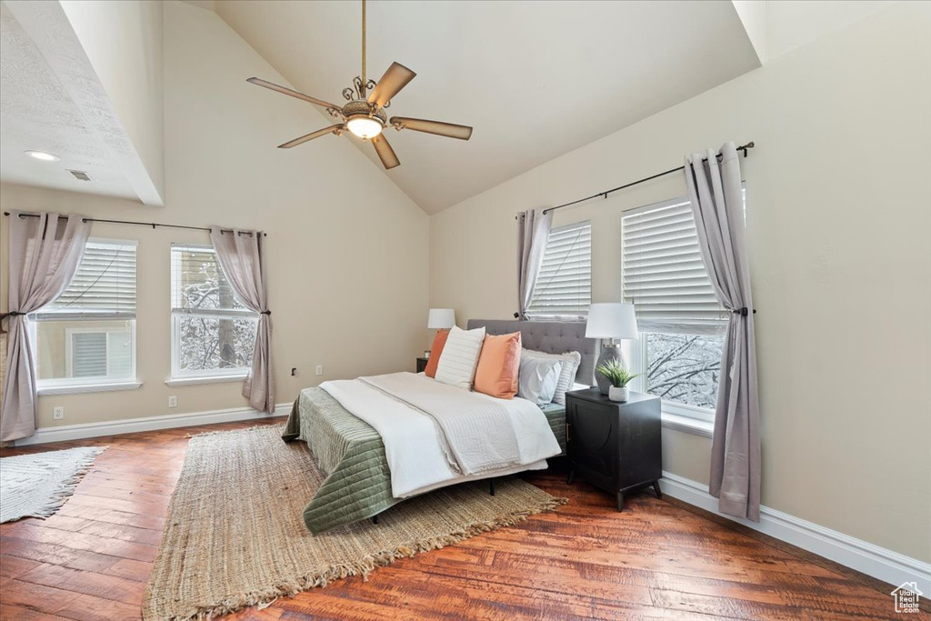 Bedroom with hardwood / wood-style flooring, multiple windows, and baseboards