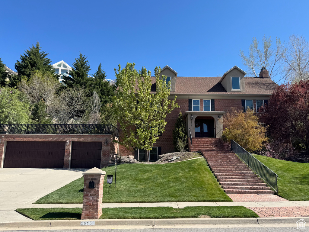 Traditional-style house with brick siding, a front lawn, and concrete driveway