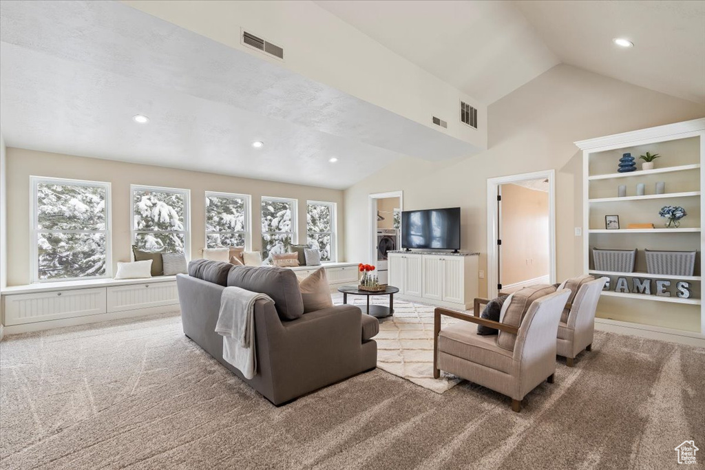 Carpeted living area featuring recessed lighting, visible vents, and high vaulted ceiling