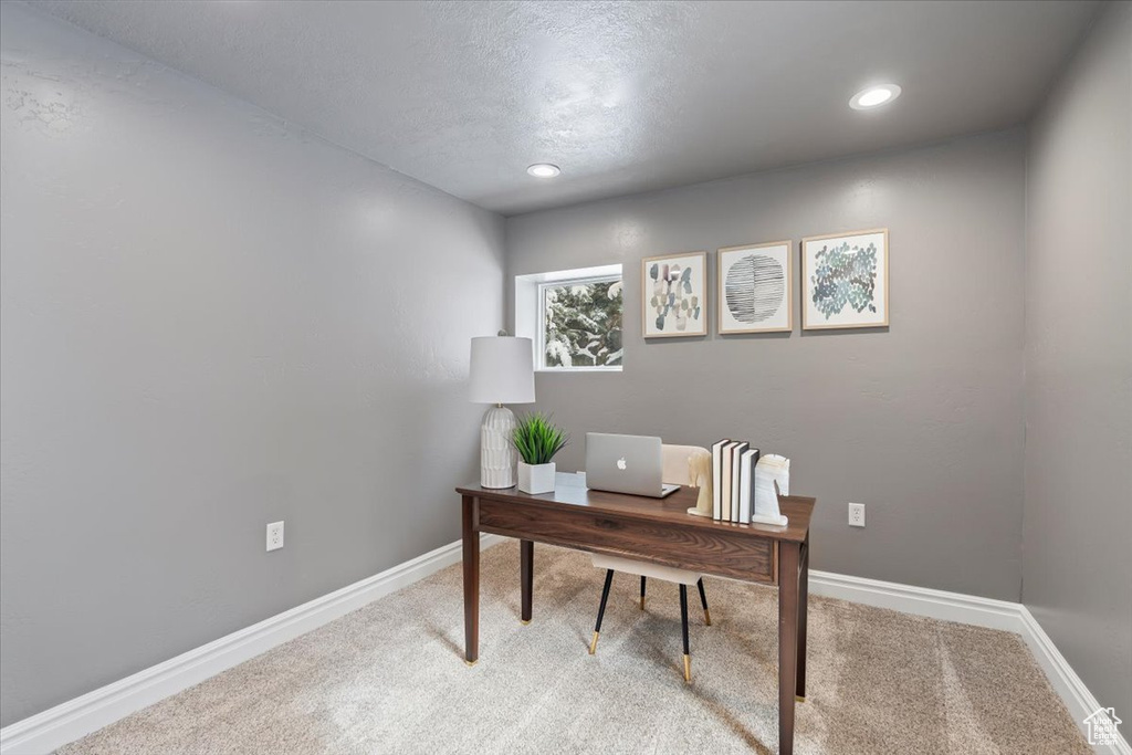 Home office with recessed lighting, light colored carpet, a textured ceiling, and baseboards