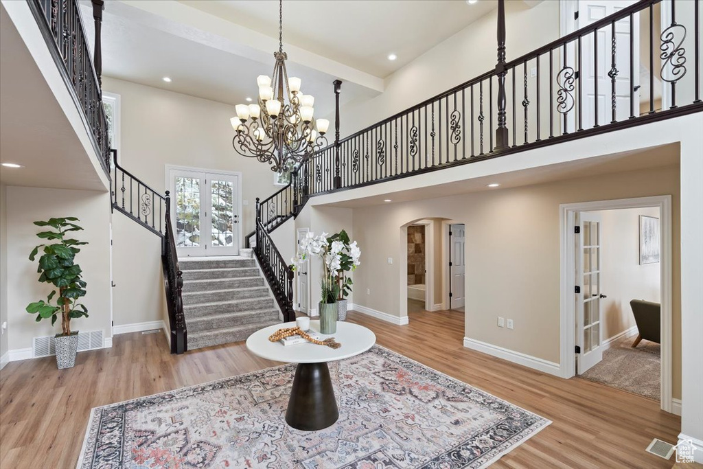 Entrance foyer with stairs, wood finished floors, french doors, and baseboards