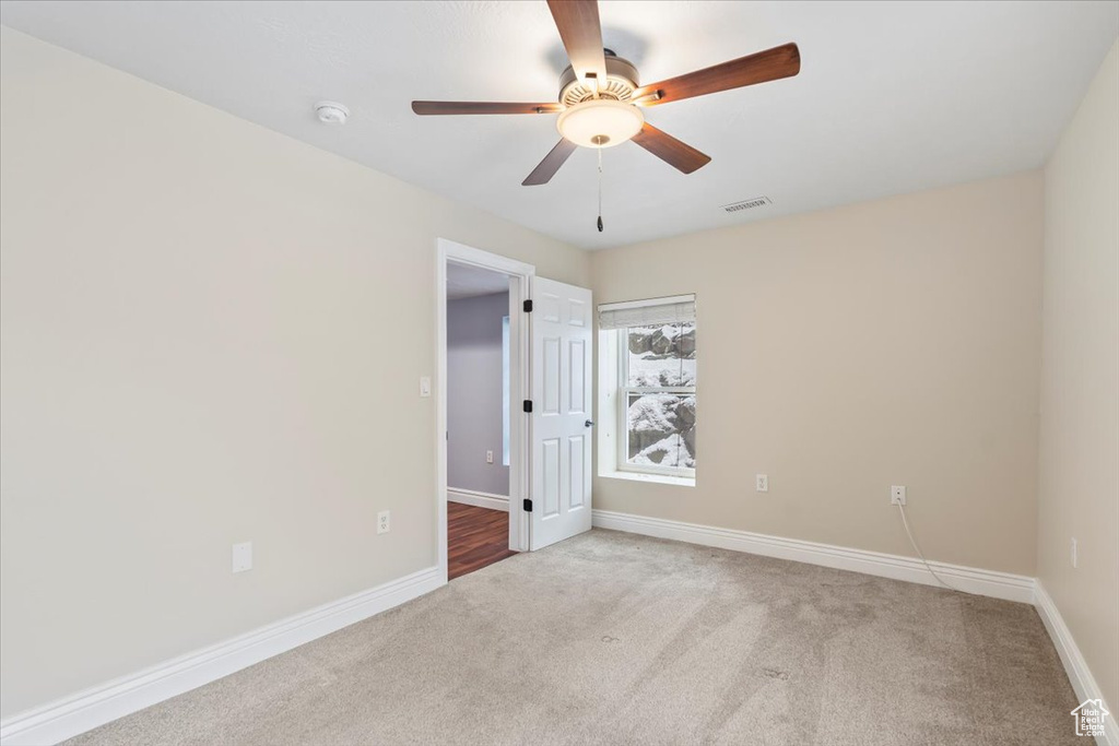 Unfurnished room with visible vents, carpet flooring, a ceiling fan, and baseboards
