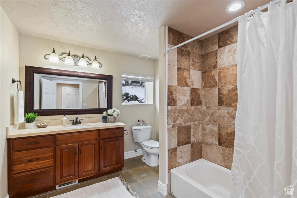 Full bathroom featuring vanity, visible vents, shower / bath combo, a textured ceiling, and toilet