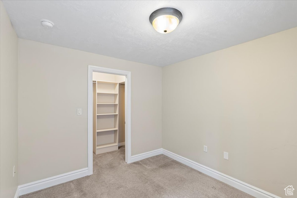 Spare room with baseboards, a textured ceiling, and carpet flooring