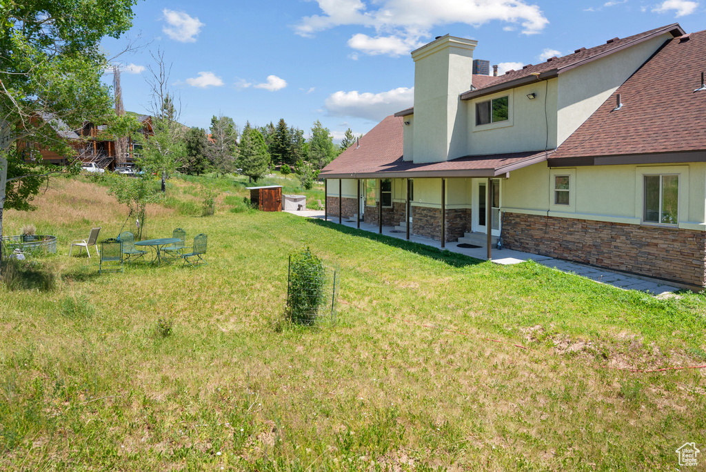 View of green lawn featuring a patio