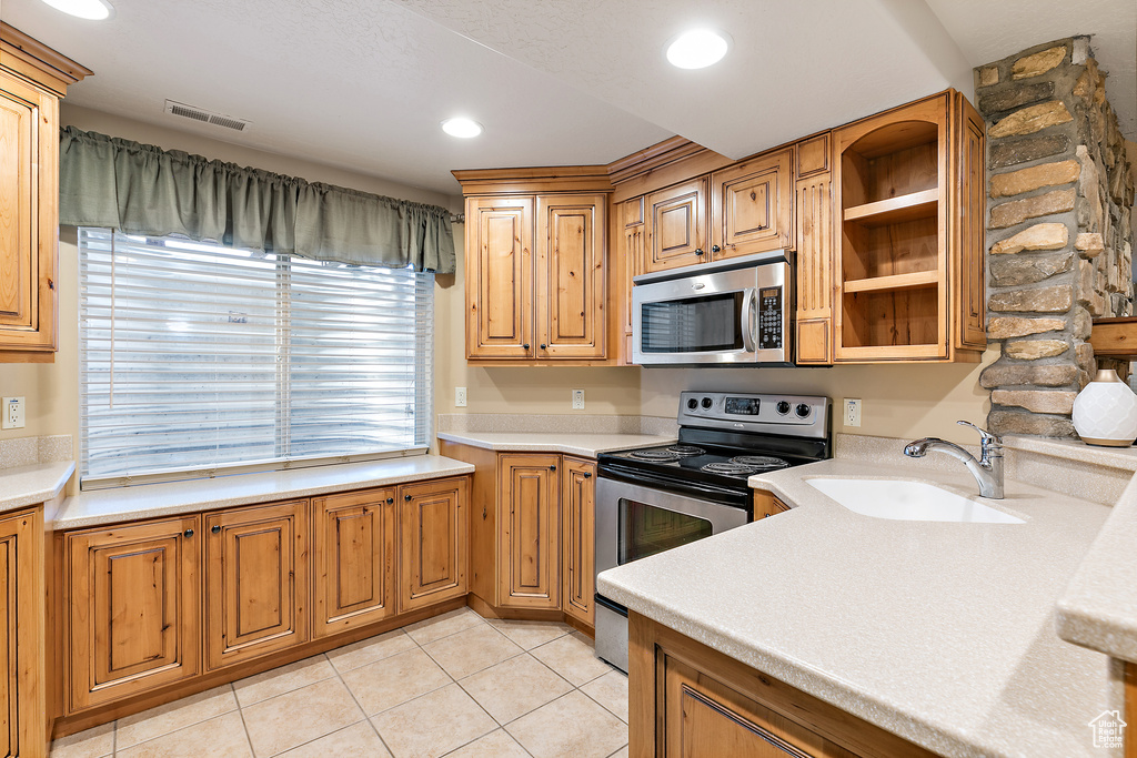 Kitchen featuring visible vents, light countertops, light tile patterned floors, stainless steel appliances, and a sink