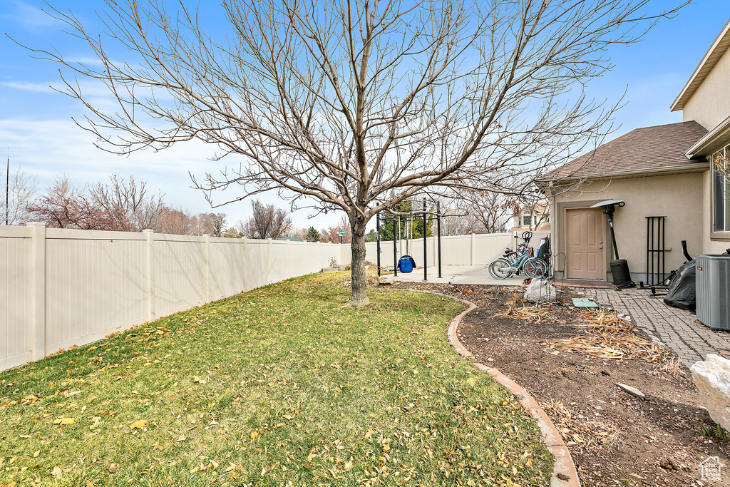 View of yard with a patio area, central air condition unit, and a fenced backyard