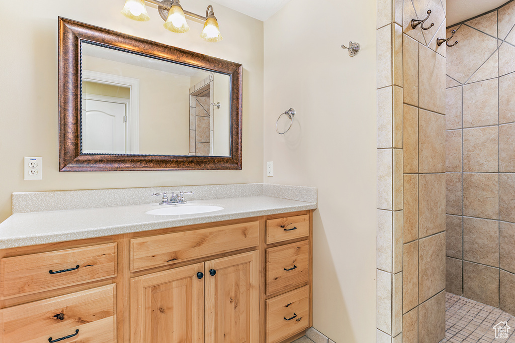 Full bath with a tile shower and vanity