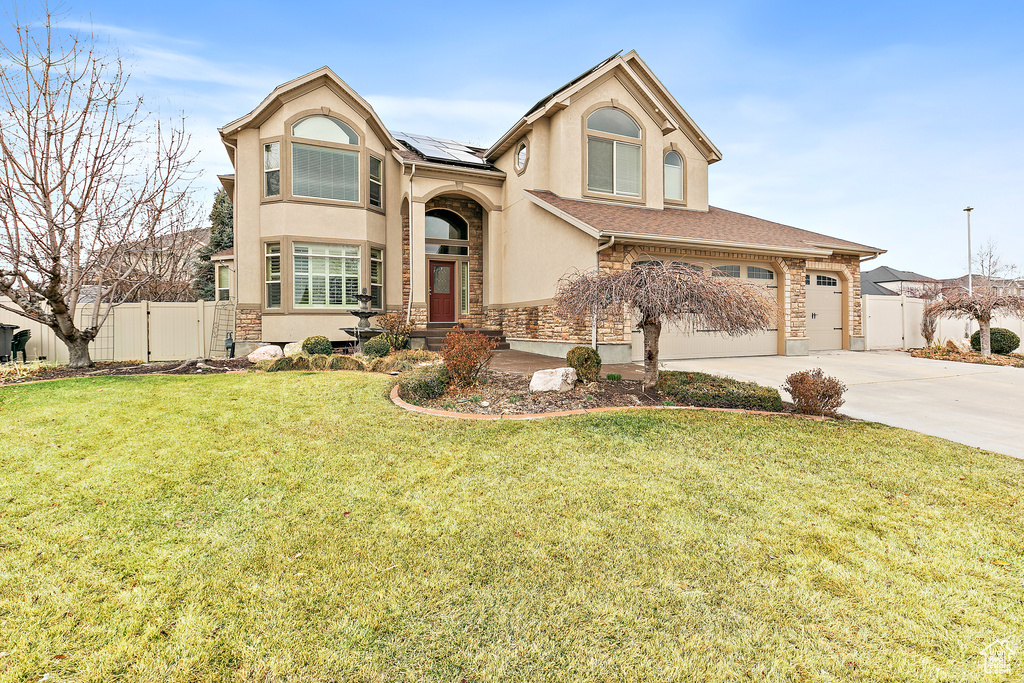 Traditional home with stucco siding, fence, concrete driveway, and a gate