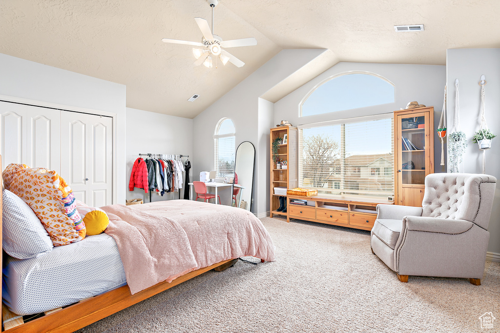 Bedroom featuring visible vents, carpet floors, vaulted ceiling, a closet, and a textured ceiling