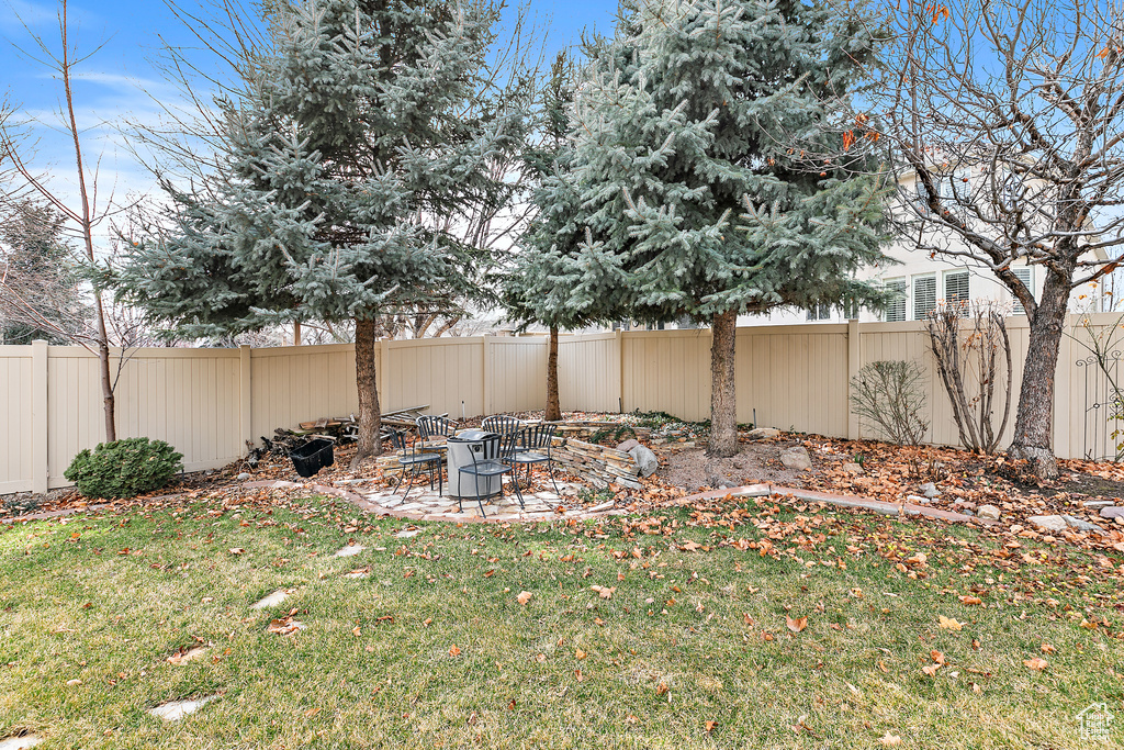 View of yard featuring a fire pit and a fenced backyard