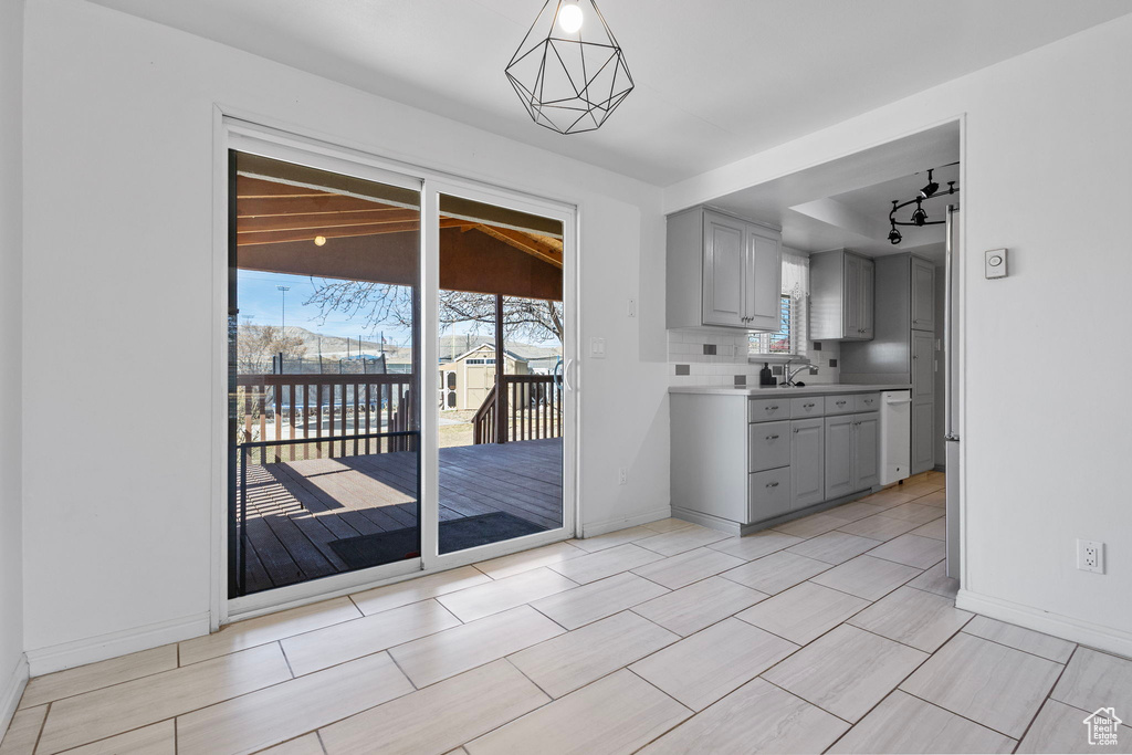 Kitchen with light countertops, baseboards, tasteful backsplash, and gray cabinetry