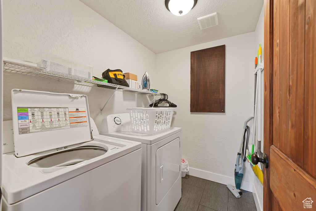 Laundry room featuring visible vents, baseboards, laundry area, a textured ceiling, and washing machine and dryer