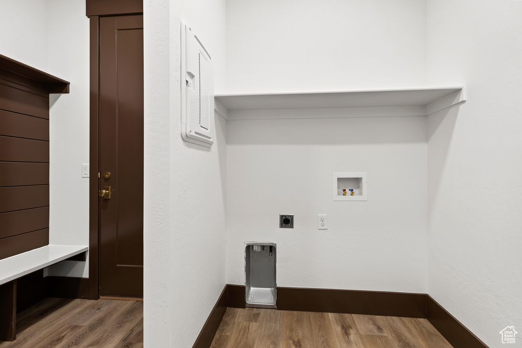 Laundry room featuring wood finished floors, baseboards, hookup for an electric dryer, hookup for a washing machine, and laundry area