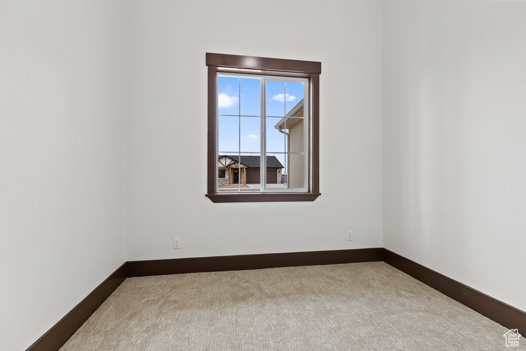 Carpeted spare room with baseboards