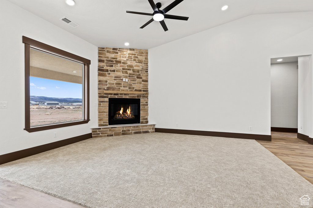 Unfurnished living room with visible vents, a ceiling fan, wood finished floors, a fireplace, and baseboards
