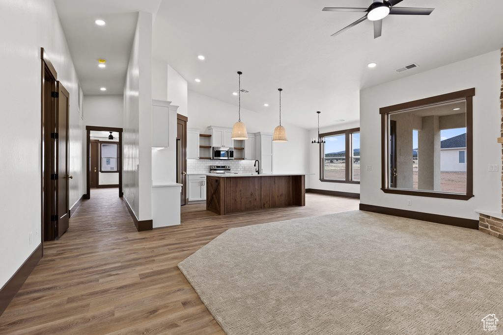 Kitchen with visible vents, open floor plan, appliances with stainless steel finishes, light countertops, and ceiling fan