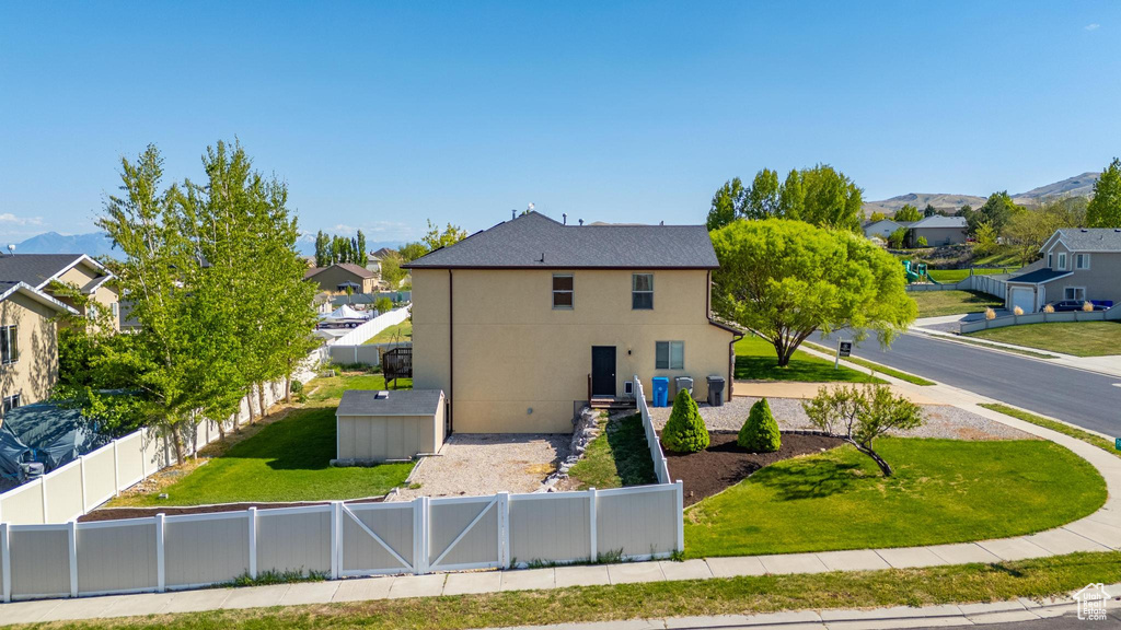 Exterior space with stucco siding, a residential view, a fenced backyard, and a front lawn