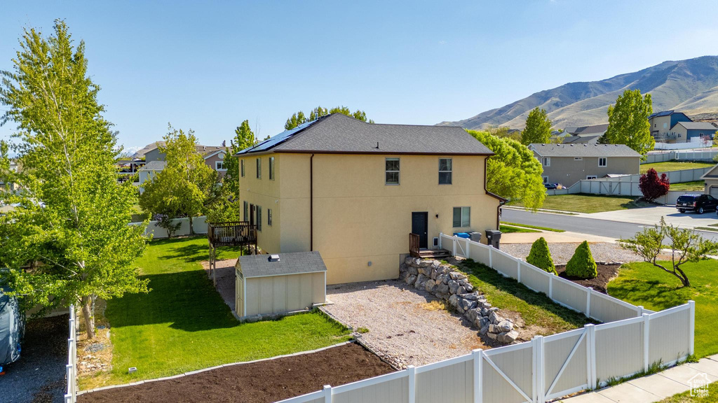 View of side of property with a lawn, a fenced backyard, a mountain view, and a residential view