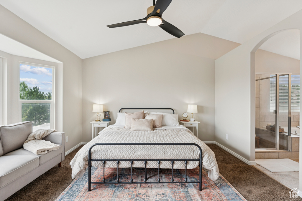 Carpeted bedroom featuring lofted ceiling, arched walkways, and a ceiling fan