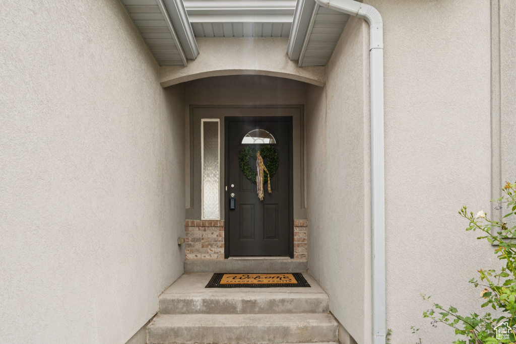 Doorway to property featuring stucco siding