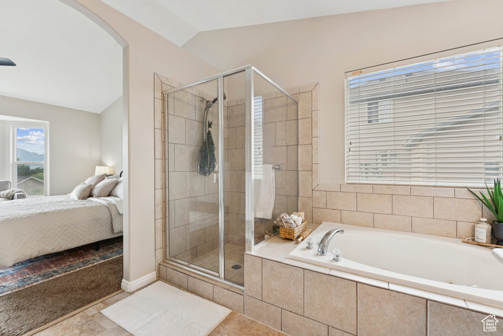 Ensuite bathroom with a bath, lofted ceiling, and a stall shower