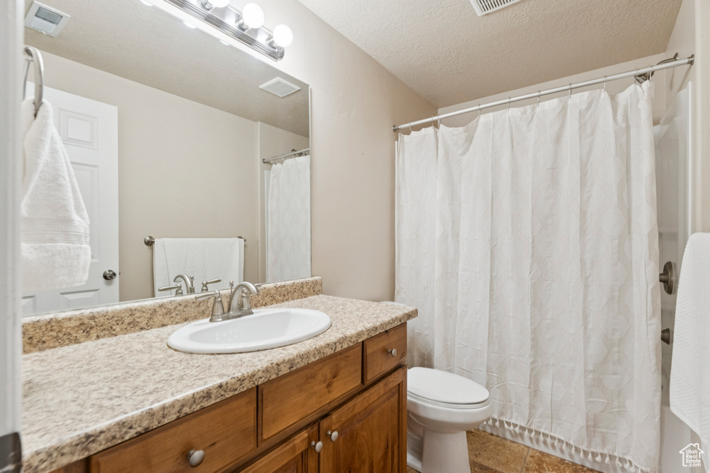 Full bathroom with vanity, tile patterned flooring, a textured ceiling, and curtained shower
