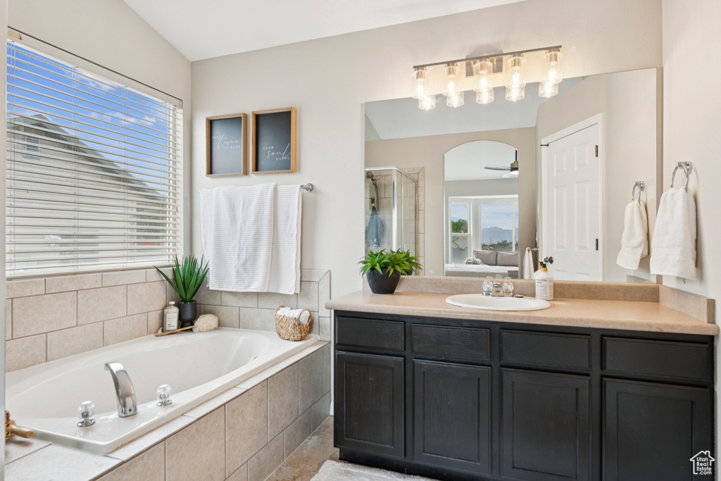 Bathroom featuring a bath, vanity, a stall shower, and ceiling fan