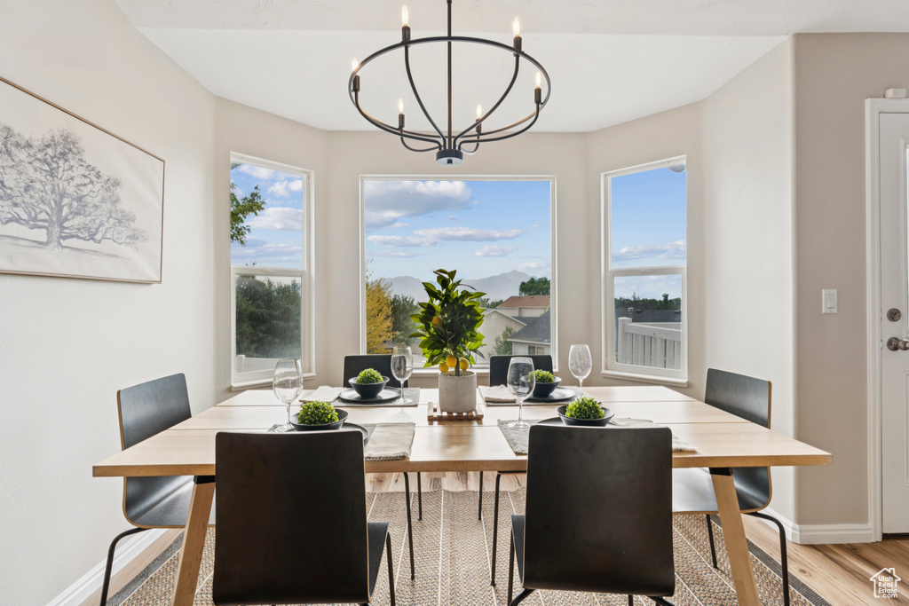 Dining room featuring light wood-style flooring, plenty of natural light, and a chandelier