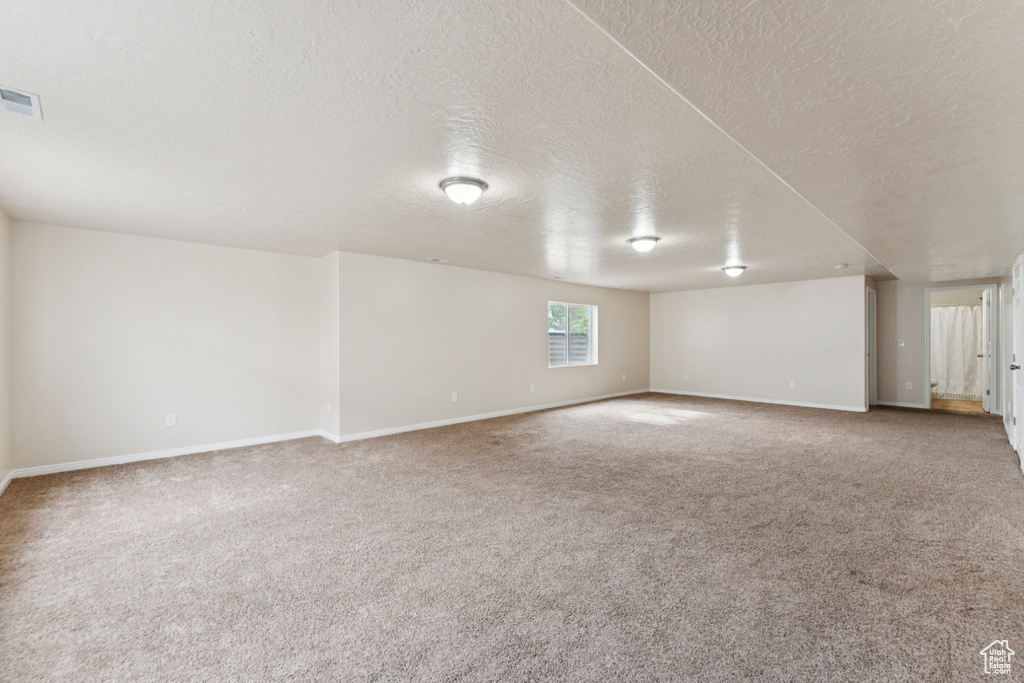 Carpeted empty room featuring a textured ceiling