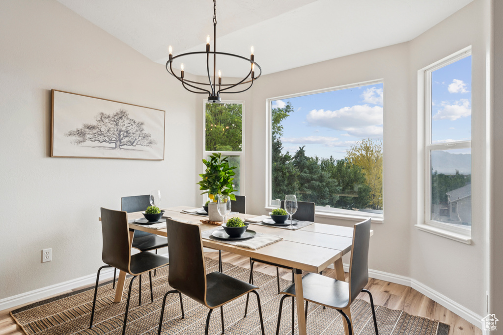 Dining room featuring a chandelier, light wood finished floors, and healthy amount of natural light