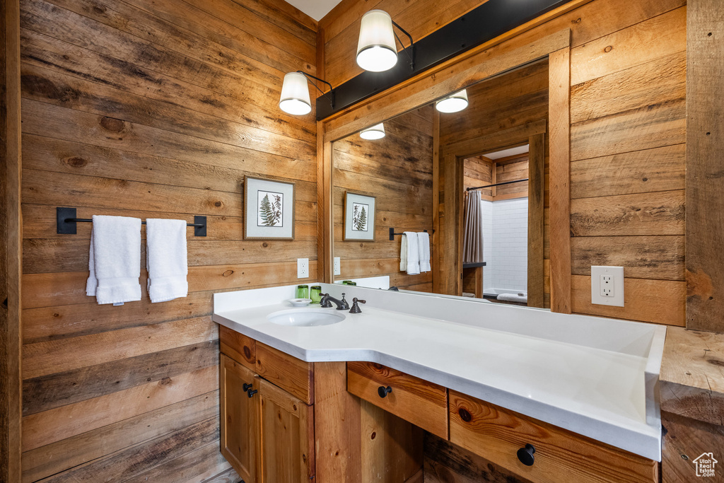 Bathroom featuring wooden walls and vanity