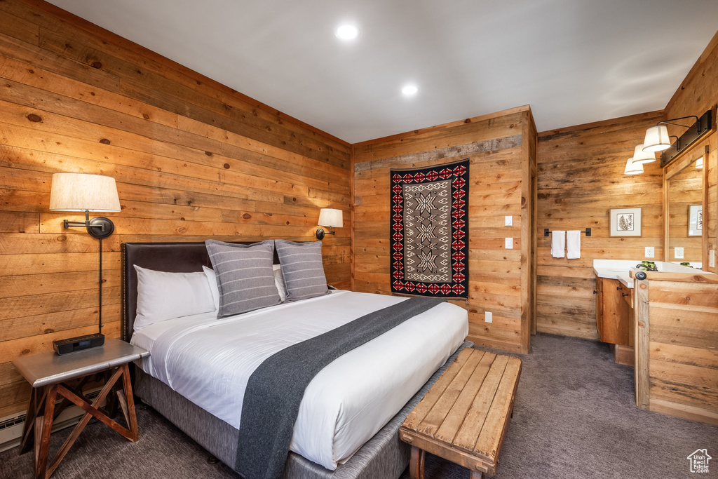 Carpeted bedroom with wood walls and recessed lighting