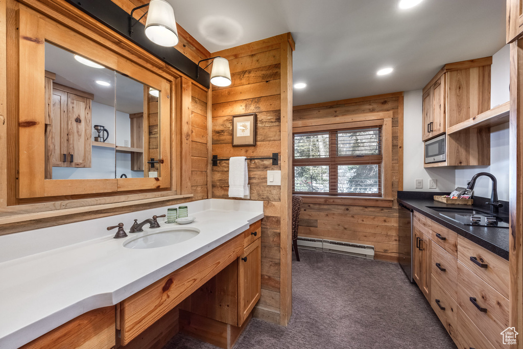 Bathroom featuring a baseboard heating unit, wooden walls, vanity, and recessed lighting