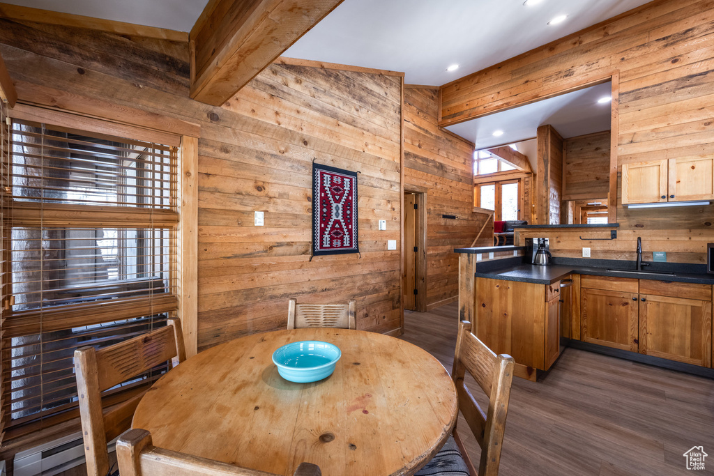 Dining space featuring wooden walls, wood finished floors, recessed lighting, and baseboard heating
