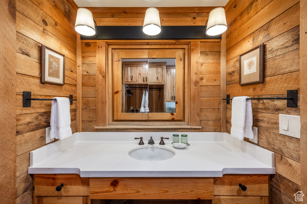 Bathroom featuring wooden walls and vanity