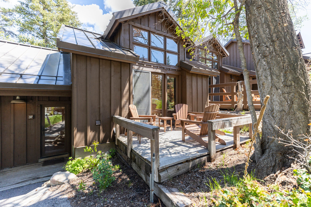 Back of house with a wooden deck and board and batten siding