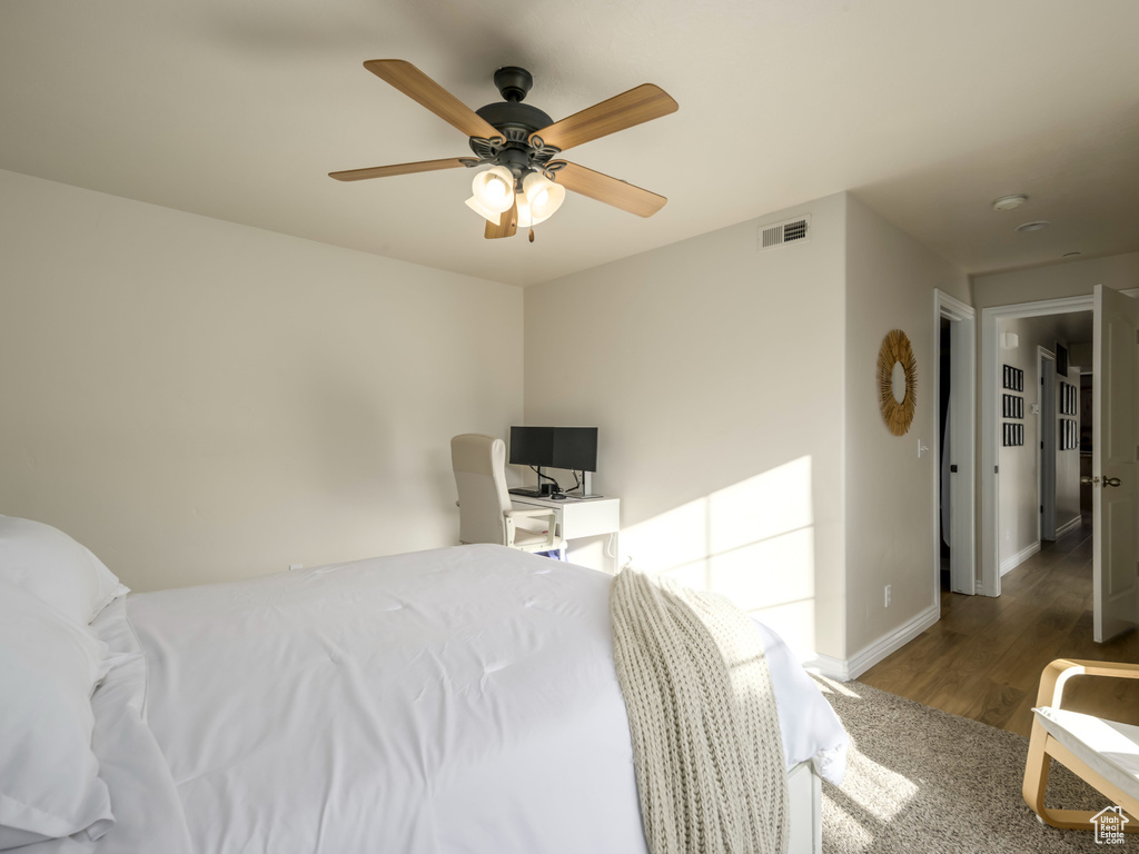 Bedroom featuring a ceiling fan, wood finished floors, baseboards, and visible vents