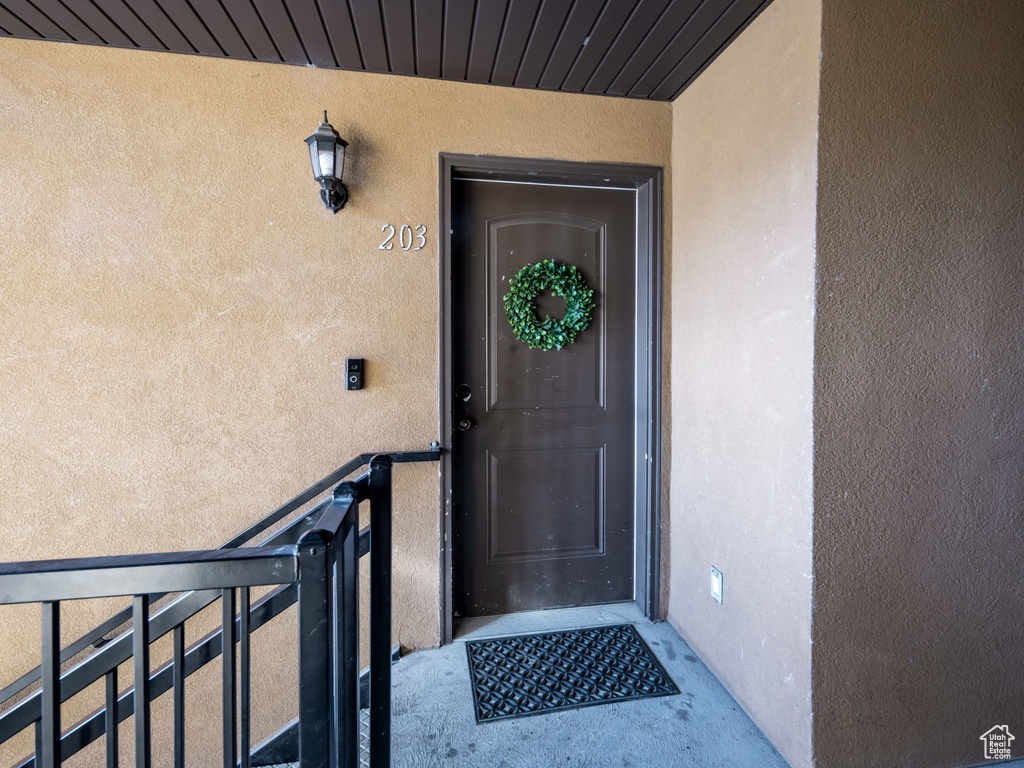 Doorway to property featuring stucco siding